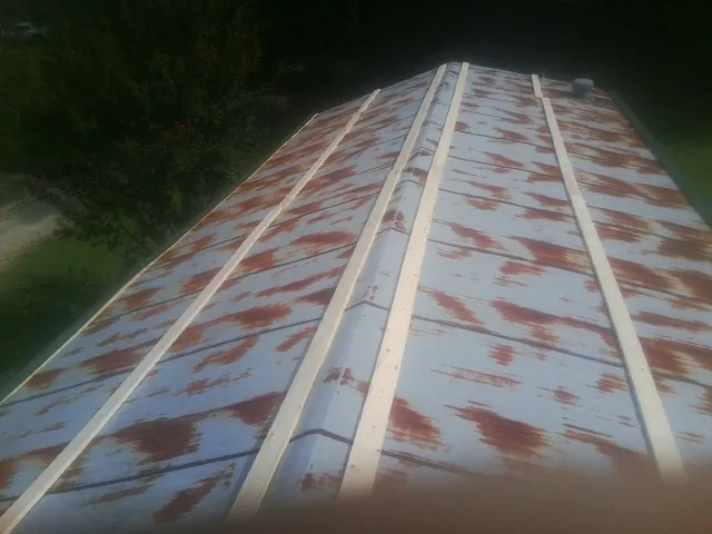 Rusted metal roof panels with new wood purlins before replacement — Storm Damage Roof Repair in Tallahassee by Roofing Brothers