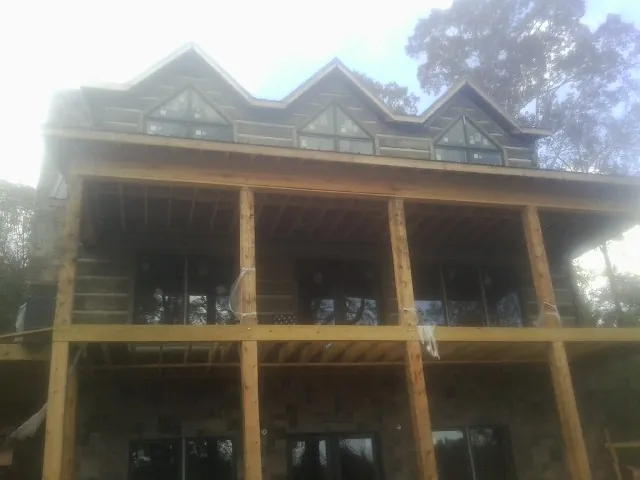 Dormers and porch framing on a large log home under construction — Roof Coating work by our crew in Tallahassee