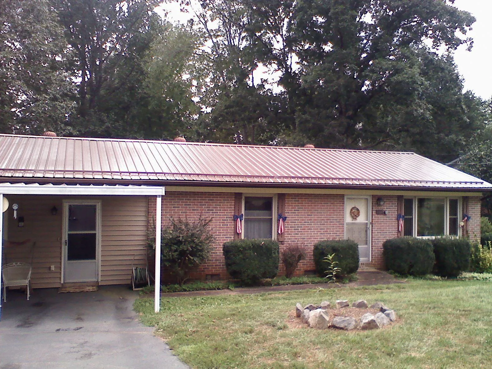 Bronze metal roof and carport on a brick ranch home — Roof Repair work by our crew in Tallahassee
